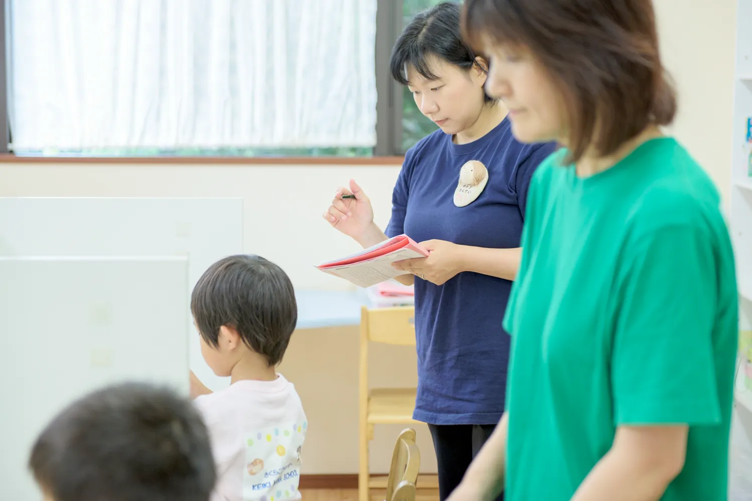 スタッフが子どもの行動や特性を見ている写真